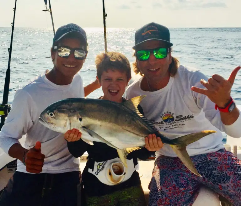 Sea Saw crew and a young guest hold a jack caught on a family fishing trip from Nosara.