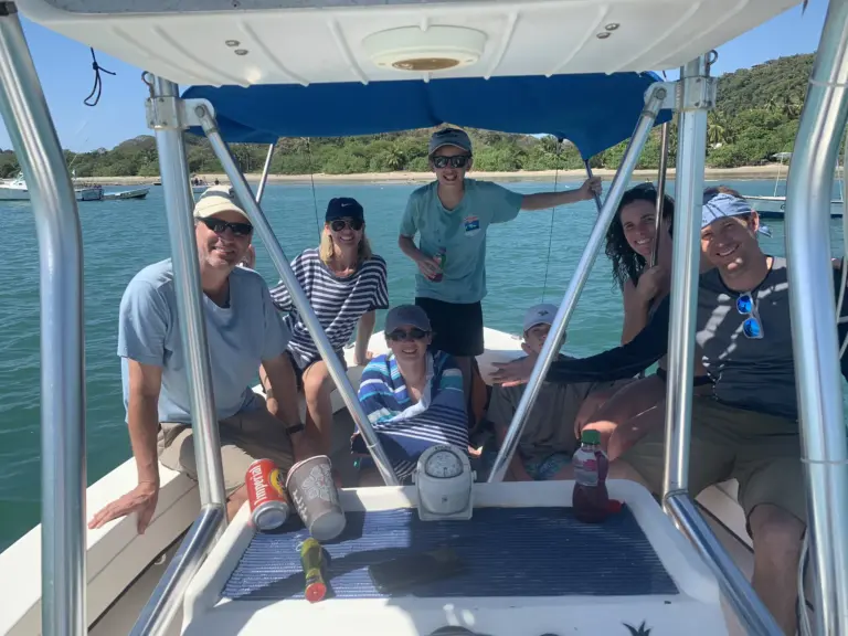 Guests of all ages sit together on the boat at anchor near the Nosara coast.
