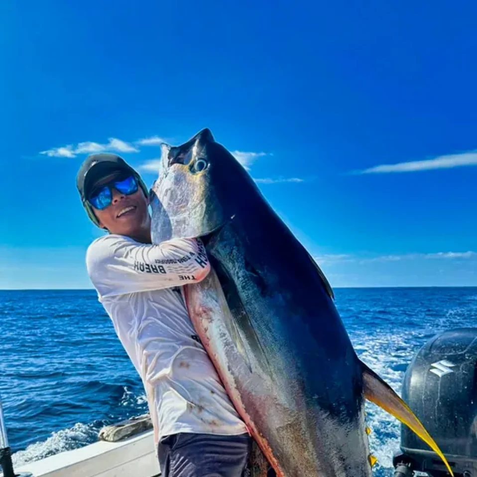 Chatel, mate of the Nosara Sea Saw Tours crew, holds a large yellowfin tuna on the boat off Playa Garza.