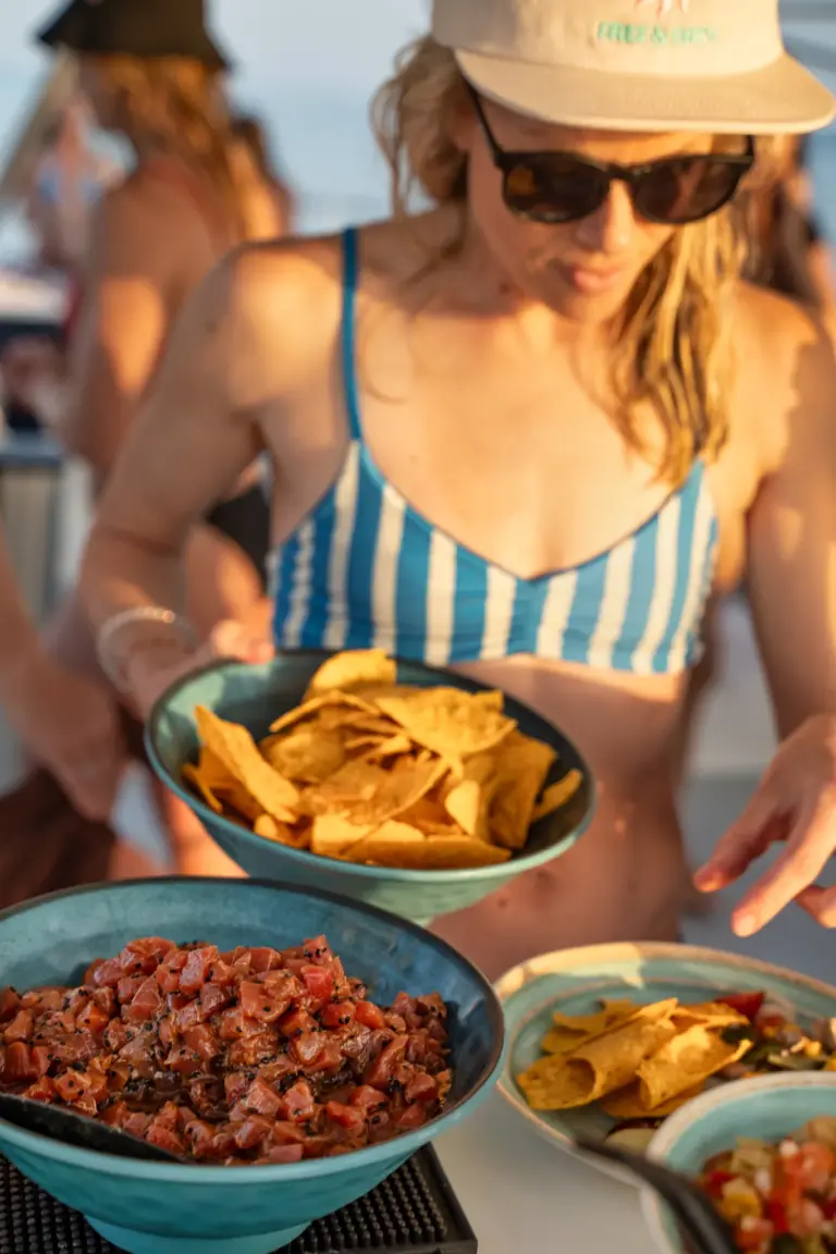 A guest serves herself nachos, salsa and fresh ceviche from bowls on the boat's table.