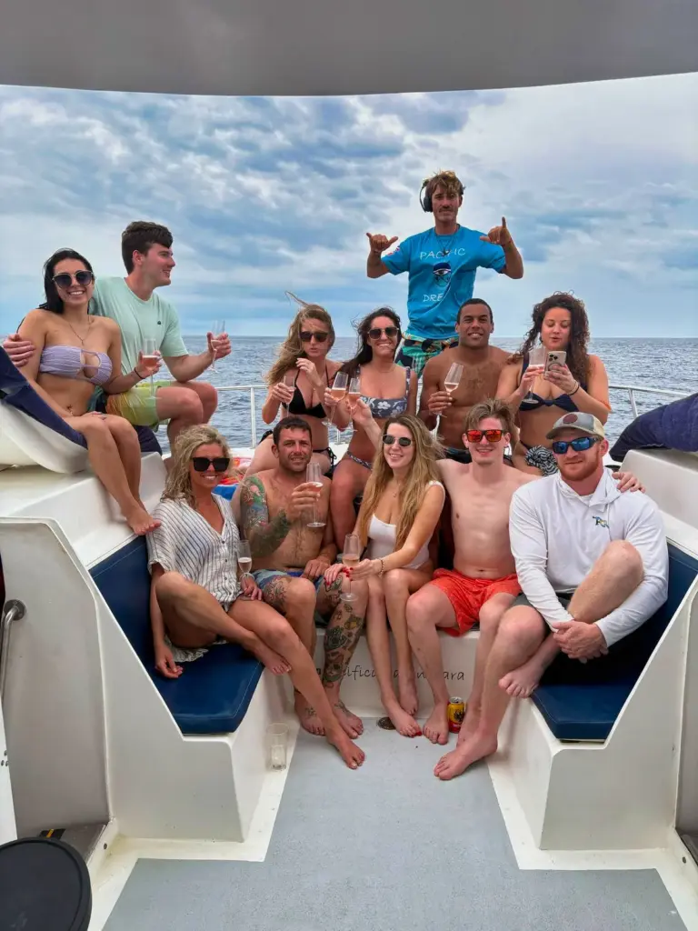 Guests fill the catamaran's stern seating with drinks on a bright day off Nosara.