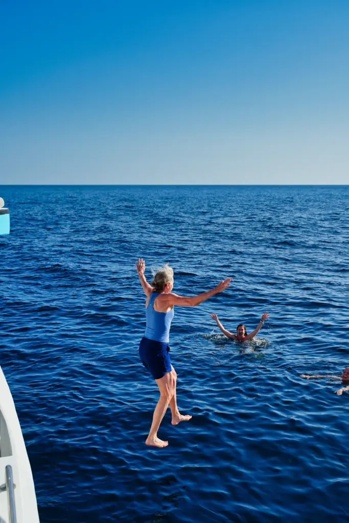 A guest jumps feet first from the catamaran into open blue water off the Nosara coast.