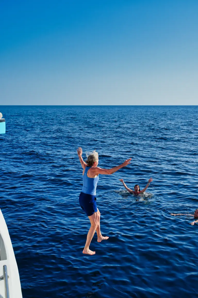 A guest jumps feet first from the catamaran into open blue water off the Nosara coast.