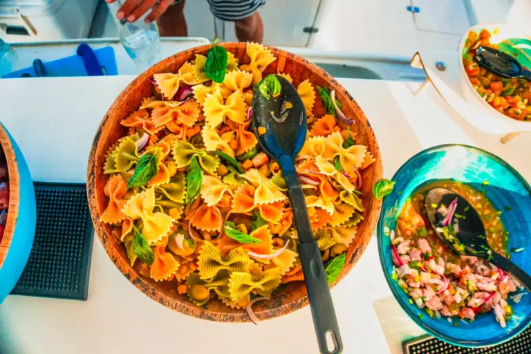 Bowls of pasta salad, ceviche and fresh sides laid out on the catamaran's table.