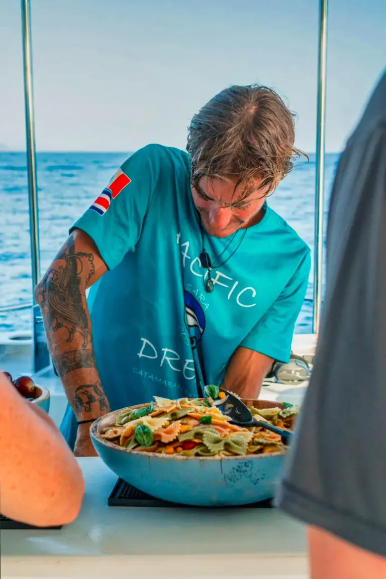 A crew member serves a fresh pasta salad on the boat during a Nosara combo tour.