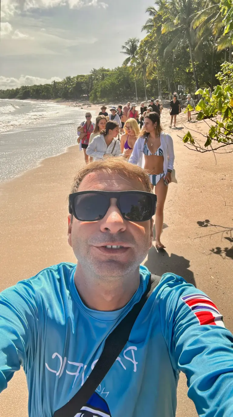 A guide takes a selfie while leading guests along a palm-lined beach in Nosara, Costa Rica.