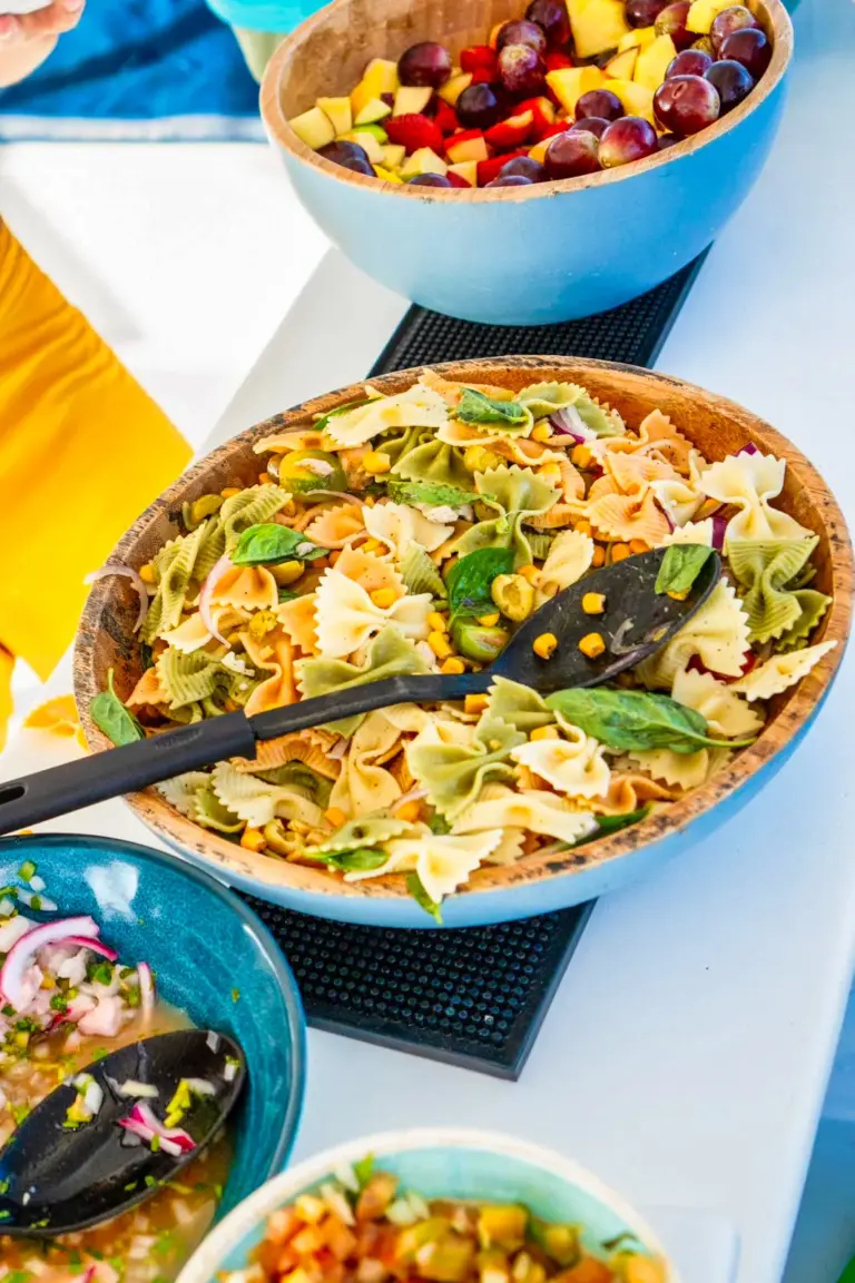 Bowls of pasta salad, ceviche and fresh fruit laid out for guests on the boat.