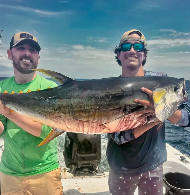 Two anglers hold up a large yellowfin tuna on the deck after an offshore trip from Playa Garza.