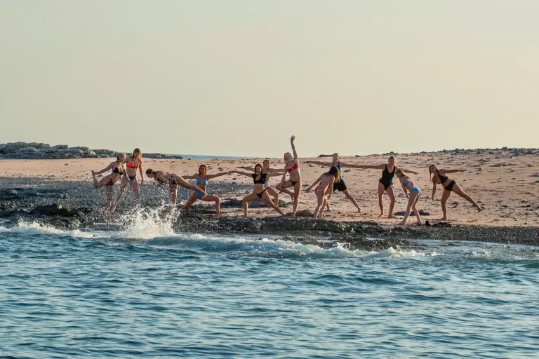 A group of guests splash and play along the exposed sandbar at Pink Island near Nosara.